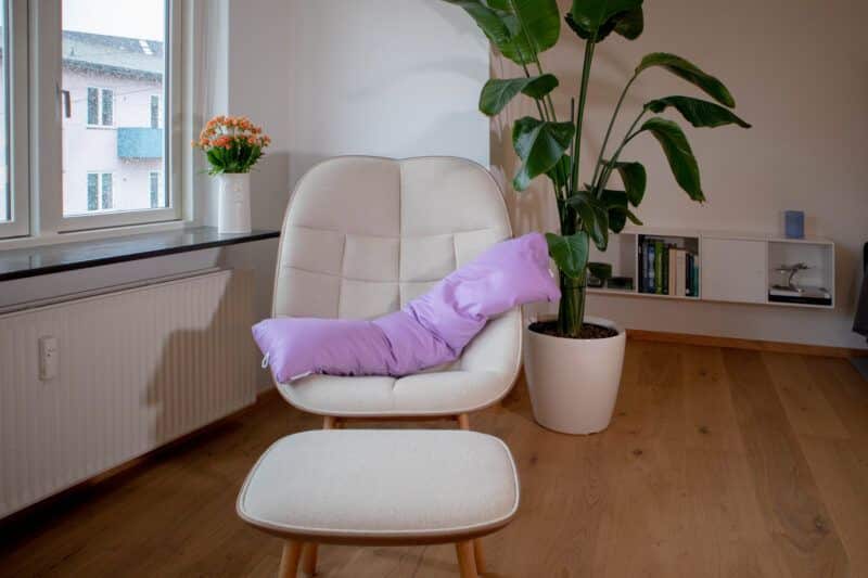 Graviditets- og ammepude fra B'Comphy (130 cm) lavendel i en stol