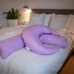 Ammepude og Graviditets- og ammepude fra B'Comphy (130 cm) lavendel i en seng