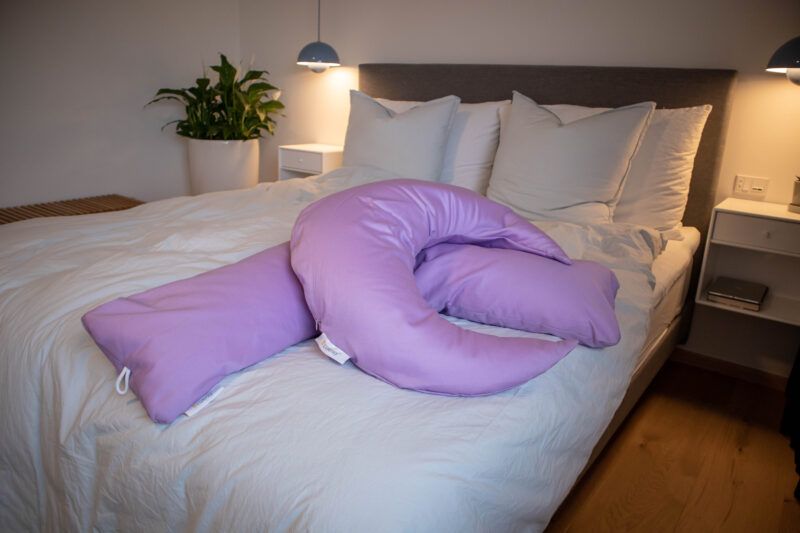 Ammepude og Graviditets- og ammepude fra B'Comphy (130 cm) lavendel i en seng